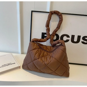 Close-up of brown quilted puffer shoulder bag with classic rhombus pattern detail