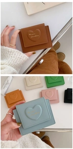 Macro shot of PU leather wallet with embossed heart patterns and gold lettering