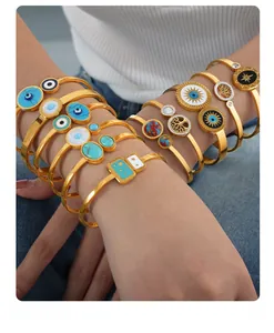 Detailed stack of gold evil eye and tree of life bracelets on a female model arm