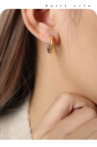 Detail of gold geometric earrings with hammered texture on a model wearing them
