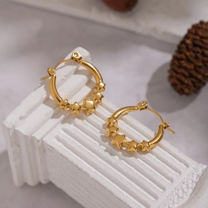 Elegant 18K gold plated stainless steel hoop earrings with small star charms on white pillar