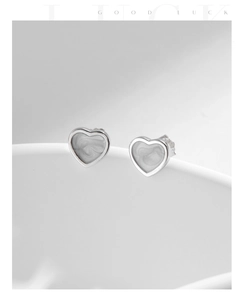Dettaglio del marchio S925 su orecchini a cuore con finitura effetto marmo