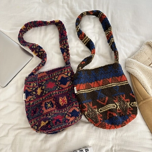 Detail of plush ethnic shoulder bag with vibrant patterns and small woven side labels