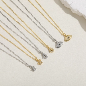 Detail of evil eye and angel wing necklaces in gold and silver with zircon stones