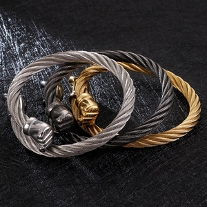 Three men's steel cable bracelets with fist clasp in gold, silver, and gun black finishes