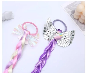 Détails d'élastiques licorne avec tresses colorées, ailes et nœuds irisés