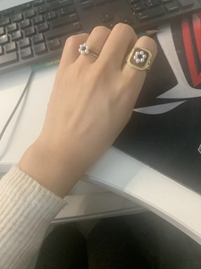 Detailed shot of vintage brass gold-plated rings with pearls and enamel on hand