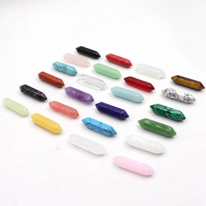 Assortiment hexagonale natuursteen kristallen zuilen in diverse kleuren op wit