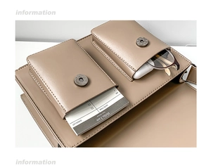 Detail of khaki leather messenger bag showing front pockets and magnetic buckle closure