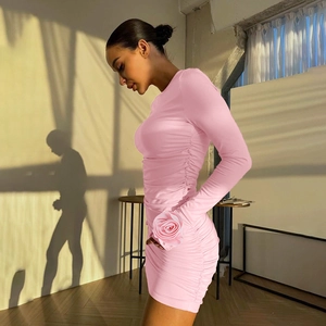 Close-up of pink ruched mini dress featuring a 3D rose detail on the long sleeve cuff