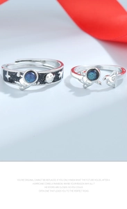 Detail of astronaut couple rings with blue starry glass and adjustable silver bands