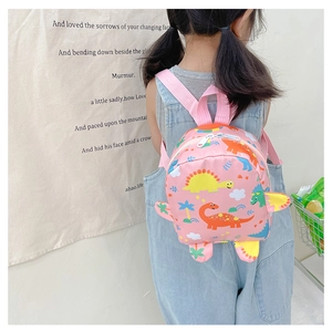 Rear view of child wearing pink canvas dinosaur backpack with 3D fins and colorful prints