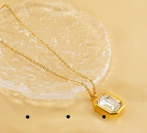 Macro shot of gold stainless steel necklace with a square cut zircon and fine polish finish