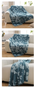 Detailed texture of blue knitted plush throw blanket on a modern white sofa