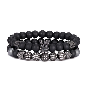 Détail de bracelets en perles noires mates avec breloque couronne et boules de zircon