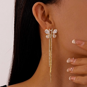 Close-up of dangling butterfly tassel earrings with sparkling rhinestones on model