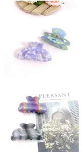 Macro shot of French acetate hair claws showing marble textures and metal spring detail