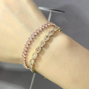 Detailed view of rose gold marquise and gold oval zircon tennis bracelets on a wrist