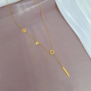 Detailed close-up of a minimalist gold pendant necklace featuring EVO letters on fabric