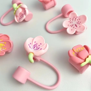 Pink cherry blossom silicone straw cover caps for Stanley cups on white background