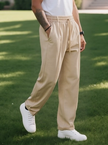 Dettaglio dei pantaloni casual beige da uomo con coulisse e pieghe frontali nette