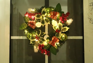 Detail of 50cm Christmas wreath with LED lights, red berries, and festive bows