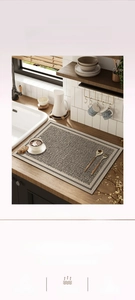 Absorbent kitchen mat with black and grey geometric pattern on a wooden countertop