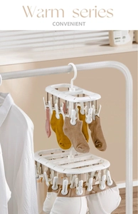 Close-up of a white rotating laundry drying rack with windproof clips for socks
