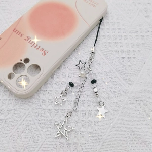 Y2K metallic star and cross phone strap with beads and pearl on white lace background