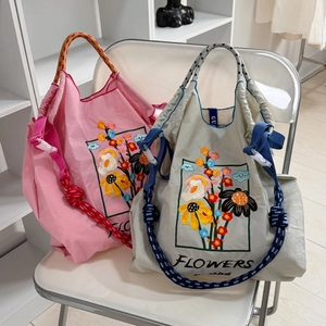 Chic nylon drawstring tote bags with vibrant floral embroidery and woven straps