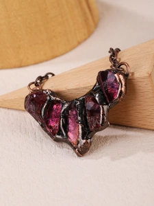 Macro detail of raw purple crystal pendant with rustic hand-textured bronze metal base
