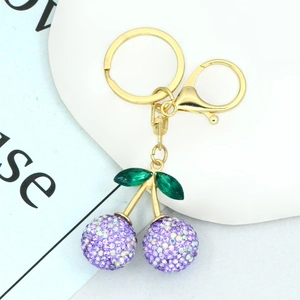 Detailed view of cherry keychain with purple rhinestones and golden metal ring hardware
