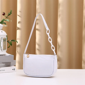 White crocodile pattern hobo bag with thick chain strap shown in an elegant home setting