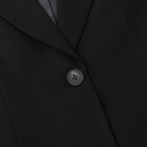 Detailed shot of notch lapel and black button on a elegant lace patchwork suit jacket