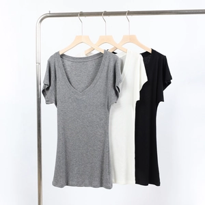 Three V-neck t-shirts in grey, white and black colors hanging on a metal rack