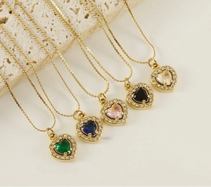 Polished stainless steel heart-shaped zircon pendants in five colors on beige stone