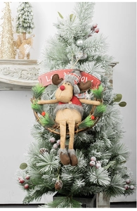 Detail of Christmas reindeer wreath with red knitted scarf and pine needles on rattan ring