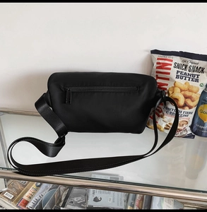 Détail du sac bandoulière tactique noir avec sangle ajustable et poches zippées
