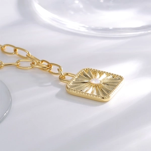 Vintage gold sunburst pendant necklace featuring a square frame with a white opal center stone