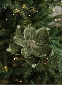 Detail of dark green velvet magnolia Christmas flower with gold sequins on a tree