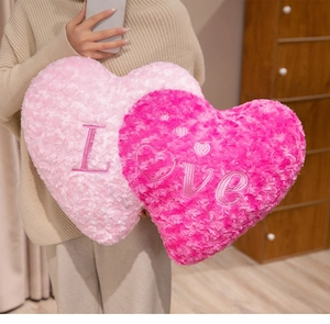 Close-up of pink and rose red heart plush pillows with LOVE embroidery detail
