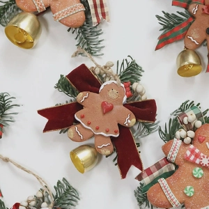 Christmas gingerbread man hanging ornament with velvet bow, golden bell and pine needle