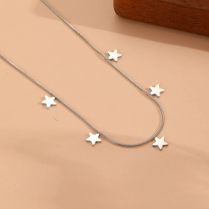 Collier chaîne serpent argentée avec plusieurs pendentifs étoiles au style minimaliste