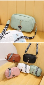 Detail of woven texture crossbody bag with metal cat pendant and colorful strap options
