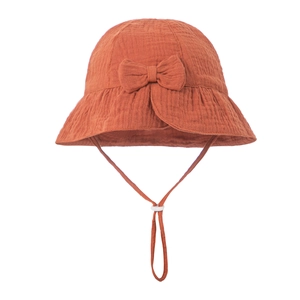 Detailed texture of cotton gauze baby bucket hat with bow and adjustable chin strap