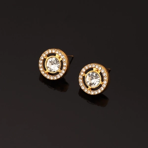Detail view of round gold crystal stud earrings with large center stone on black background