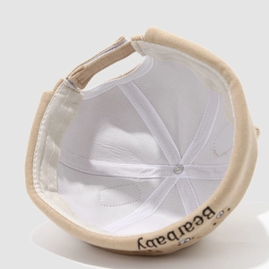 Dettaglio interno con cuciture rifinite e logo Bearbaby sul cappello docker in tela beige