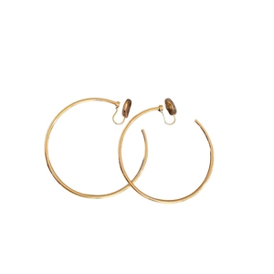 Minimalist large golden round hoop clip-on earrings with smooth metallic finish