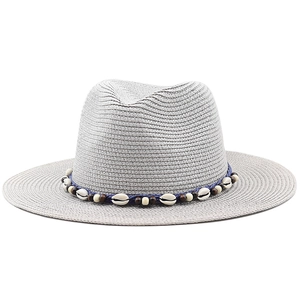 Grey Panama straw hat featuring a bohemian rope band with sea shells and wooden beads