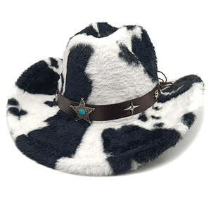 Détail du chapeau de cowboy motif vache avec bande en cuir, étoiles et pierre turquoise